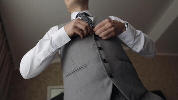 Buttoning jacket with hands close up, man in suit fastens buttons on his jacket preparing to go out video