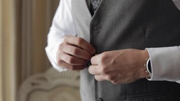 Buttoning jacket with hands close up, man in suit fastens buttons on his jacket preparing to go out video