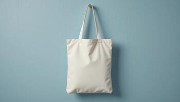 Minimalist White Tote Bag Hanging Against a Light Blue Wall in a Modern Setting photo