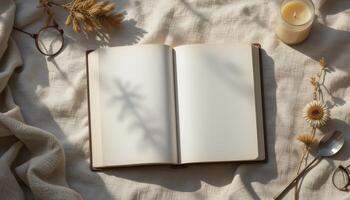 Open Blank Notebook on a Textured Surface With Natural Decor and Candlelight During Daytime photo