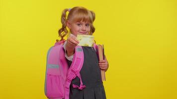 Cheerful funny school girl kid in uniform hold in hand bank credit card showing thumbs up gesture, video