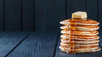 A scrumptious stack of pancakes generously topped with creamy butter and rich syrup ready to be enjoyed at breakfast photo
