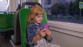Girl playing on smartphone, chatting, texting, browsing social media while traveling by tram to city video
