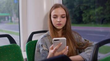 Woman playing on smartphone, chatting, texting, browsing social media while traveling by bus to city video