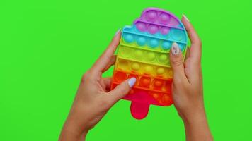 Hands playing colorful squishy silicone bubbles sensory toy game isolated on chroma key background video