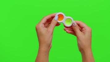 Hands holding colorful silicone bubbles sensory toy simple dimple isolated on chroma key background video