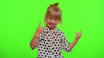 Overjoyed kid showing rock n roll gesture by hands, cool sign, dancing rejoicing in success win video