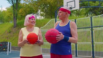 Active senior basketball team man woman playing game with ball, smiling looking at camera at stadium video