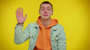 Man teenager smiling friendly at camera and waving hands gesturing hello or goodbye, welcoming video