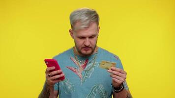 Man use mobile cell phone and plastic credit bank card, browsing say wow yes found out great big win video