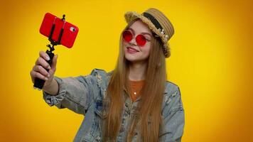Girl traveler blogger in sunglasses, taking selfie on mobile phone, communicating call online video