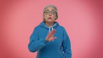Dont want to hear and listen, irritated elderly woman covering ears, gesturing no, avoiding advice video