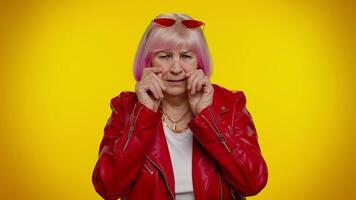 Upset disappointed senior old woman wipes tears and cries from despair, sad because of unfair things video