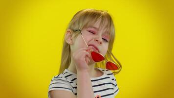 Playful happy child girl in sunglasses blinking eye, looking at camera with smile, winking, flirting video