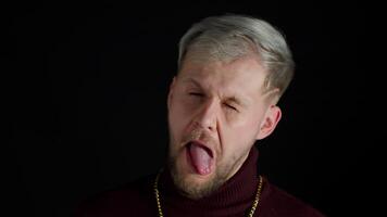 Comical stupid stylish man making funny silly face grimace, playing fool, showing tongue, brainless video