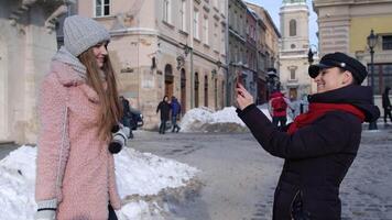 Sisters couple bloggers taking photo pictures, posing, making online vlog on mobile phone video