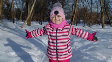 Smiling child kid looking at camera, embracing, fooling around, hugging in winter snowy park forest video