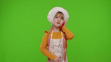 Child girl cook chef receiving online order, talking on mobile phone making conversation with client video