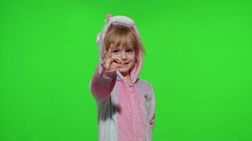 Little child girl smiling, showing thumbs up, ok gesture, agree sign in unicorn pajama on chroma key video