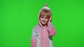 Little kid girl daughter in unicorn pajamas using speaking talking on mobile cell phone with mother video