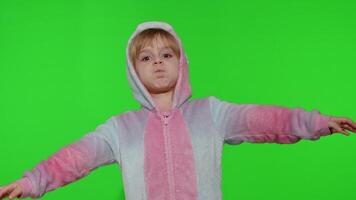 Child girl in unicorn pajamas making silly funny faces, fooling around, showing tongue on chroma key video