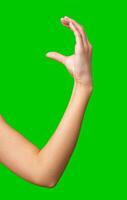 Hand gesture demonstrating the symbol of good luck on a bright green background photo