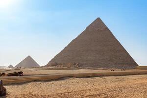 Stunning view of the Great Pyramids of Giza in the desert under a clear blue sky during the daytime photo