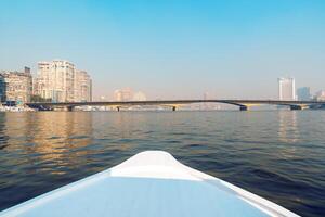 View from a boat on the river with city skyline and bridge during a clear day photo