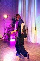 Dancer performing in a vibrant studio with colorful lighting during a creative practice session photo