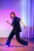Dynamic dancer showcasing expressive movement in a vibrant indoor studio setting during evening hours photo
