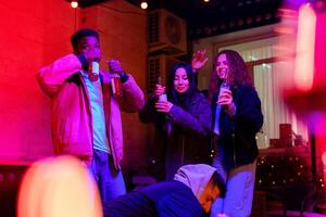 Friends enjoying drinks and dancing at a lively party in a cozy indoor venue during the evening hours photo
