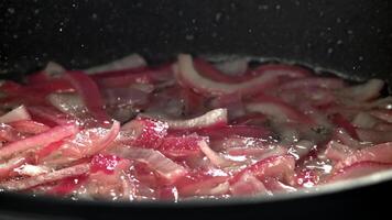 The red chopped onion is fried in a pan. Filmed on a high-speed camera at 1000 fps. High quality FullHD footage video
