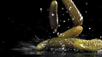 Pickled cucumbers fall on a wet table. Filmed on a high-speed camera at 1000 fps. High quality FullHD footage video