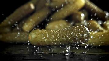 Pickled cucumbers fall on a wet table. Filmed on a high-speed camera at 1000 fps. High quality FullHD footage video
