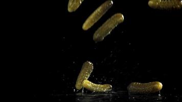 Pickled cucumbers fall on a wet table. Filmed on a high-speed camera at 1000 fps. High quality FullHD footage video