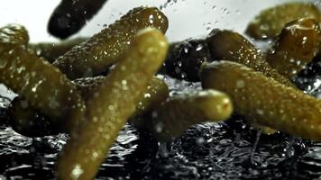 Pickled cucumbers fall on a wet table. Filmed on a high-speed camera at 1000 fps. High quality FullHD footage video