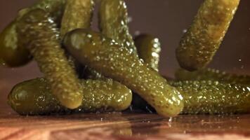 Pickled cucumbers fall on a wooden table. Filmed on a high-speed camera at 1000 fps. High quality FullHD footage video