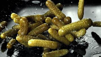Pickled cucumbers fall on a wet table. Filmed on a high-speed camera at 1000 fps. High quality FullHD footage video