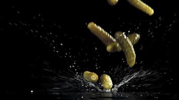Pickled cucumbers fall on a wet table. Filmed on a high-speed camera at 1000 fps. High quality FullHD footage video