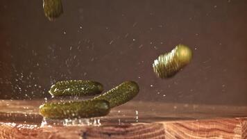 Pickled cucumbers fall on a wooden table. Filmed on a high-speed camera at 1000 fps. High quality FullHD footage video