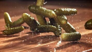 Pickled cucumbers fall on a wooden table. Filmed on a high-speed camera at 1000 fps. High quality FullHD footage video