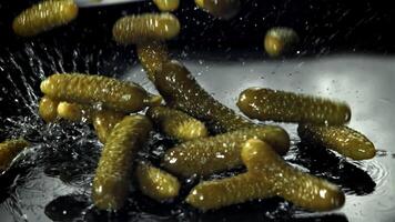 Pickled cucumbers fall on a wet table. Filmed on a high-speed camera at 1000 fps. High quality FullHD footage video