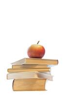 Stack of old hardcover books with red apple on top, centered on white background with copy space. photo