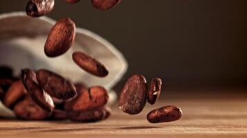 Cocoa beans fall on the table. Filmed on a high-speed camera at 1000 fps. High quality FullHD footage video