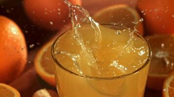 Ice cubes fall into the orange juice. Filmed on a high-speed camera at 1000 fps. High quality FullHD footage video