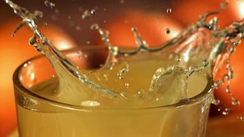 Ice cubes fall into the orange juice. Filmed on a high-speed camera at 1000 fps. High quality FullHD footage video