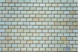 Wall of vintage bricks covered with cracked glaze. A wall with stains and cracks on the bricks. photo