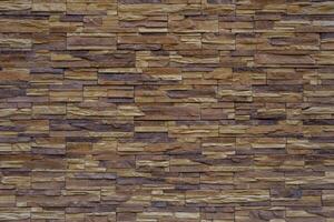 Wall made of brown and beige vintage bricks. The bricks are laid in a pattern. photo