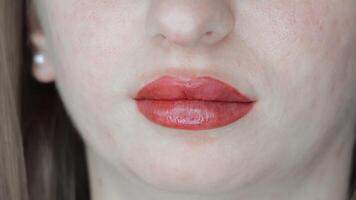 Freshly tattooed lips after permanent makeup session, soft shine and defined shape visible in closeup video