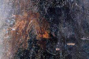 Textured surface reveals natural patterns in dark colors and subtle highlights during daytime photo